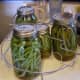 As you are finished with each jar, place it in a canning rack. You can warm your jars, and minimize damage to them, by locking your rack over the canner with the handles. This is all the beans I did in this batch.