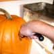 ...then switch to a serrated knife and cut to the bottom center of the pumpkin. Repeat at a different angle...