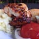 BBQ chicken served with mashed potatoes and tomato and onion salad 