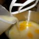 Adding lemon juice to sweetened condensed milk and egg yolks. 