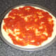 Tomato sauce is spread on the pizza base