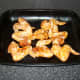 Marinated chicken wings are laid in a single layer on a large roasting or baking tray