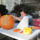 Carving their pumpkins into jack-o-lanterns