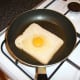 The egg is poured on to the bread that the yolk slips in to the hole