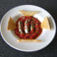 Fresh sardines cooked in homemade tomato sauce are served with hot, buttered toast.