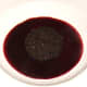 Black pudding is laid on the red wine and cranberry reduction