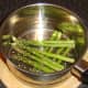 Asparagus spears are added to steamer