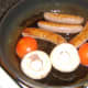 Frying sausages, mushrooms and tomato