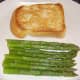Toast and asparagus spears are plated