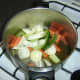 Vegetables are added to the stock pot and warmed olive oil.