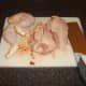 Leg portions and thighs are removed from chicken and main body halved through the breastbone