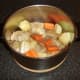 Vegetables, herbs and seasonings are added to the stew pot