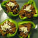 Top the stuffed peppers with shredded cheese.