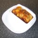 3 chicken thighs and sauce are added to a dish and the serving plate