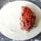 Spoon the tomato sauce on top of the sausage and bacon