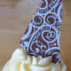 Pop the chocolate shard into the frosting and you are ready to serve.
