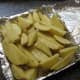 Arrange coated potato wedges in a single layer on the baking pan.