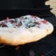 If the bottom is browning too fast, raise the pizza up to a higher grate or lower the flame.