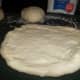 Shape the dough into pizza crusts with your hands working from the inside out.