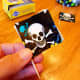 Cut skull and crossbones design from Duck Tape and wrap around a toothpick.