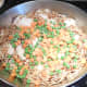 Add one cup of frozen peas and carrots (or vegetable of your choice) over the fideo and chicken. Spread evenly.