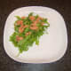 Rccket leaves (arugula) and smoked salmon are arranged on the serving plate
