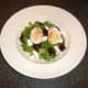 Deviled duck eggs are placed on top of beetroot and feta cheese salad