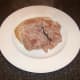 Cooked ham is removed to a plate to cool