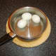Hard boiled and peeled eggs are cooled in cold water