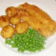 Potatoes and peas are plated alongside haddock