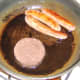Black pudding is added to pan with partly cooked sausages