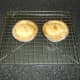 Scotch pies are rested in their casings on a wire rack