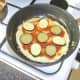 Tomato sauce and vegetable slices are added to pizza omelette