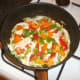 Chicken and bell peppers are scattered over the set egg