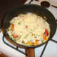 Grated cheese is scattered over the chicken and peppers