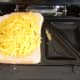 Grated cheddar cheese is scattered over haggis
