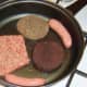 Pan-frying sausages, black pudding and haggis