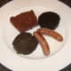 Sausages, black pudding and haggis on a heated plate.