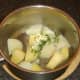 Butter and chives added to drained potato and turnip