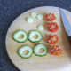 Preparing cherry tomatoes and cucumber garnish