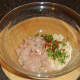 Combining chicken burger ingredients.