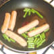 Green beans are added to fried sausages