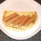 Pork sausages are laid on half naan bread