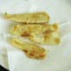 Deep fried plaice fillets are drained on kitchen paper