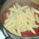 Cooked and drained penne pasta is added to tomato sauce