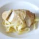 Sliced chicken breast is laid on tagliatelle bed