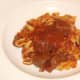 Tagliatelle with tomato and venison sauce is plated