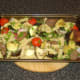 Stirring venison and pasta through roasted vegetables