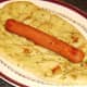 Hot dog is laid on naan bread