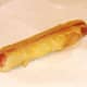 Deep fried, battered hot dog is drained on kitchen paper